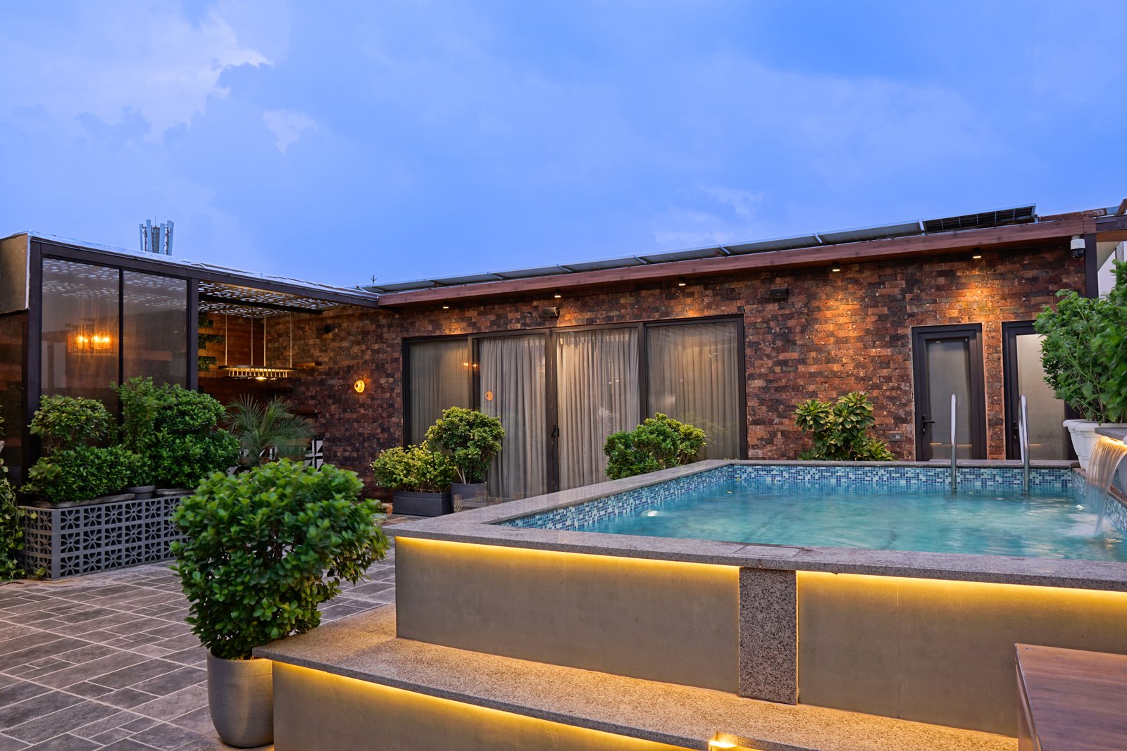 Luxury Delhi terrace at dusk with warm lighting, designed and built by Rabbit and Sparrow