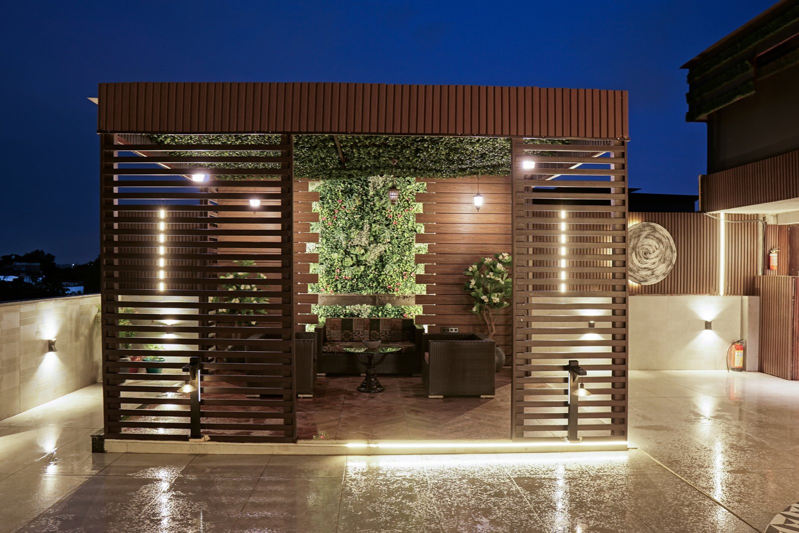 Punjabi Bagh rooftop — sculptural wave wall and tropical planting